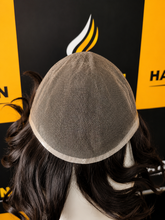 Mannequin head with a gray wig cap against a black and yellow background