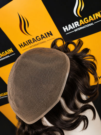 Hairpiece with a brown cap on a black and yellow 'HairAgain International' branded background