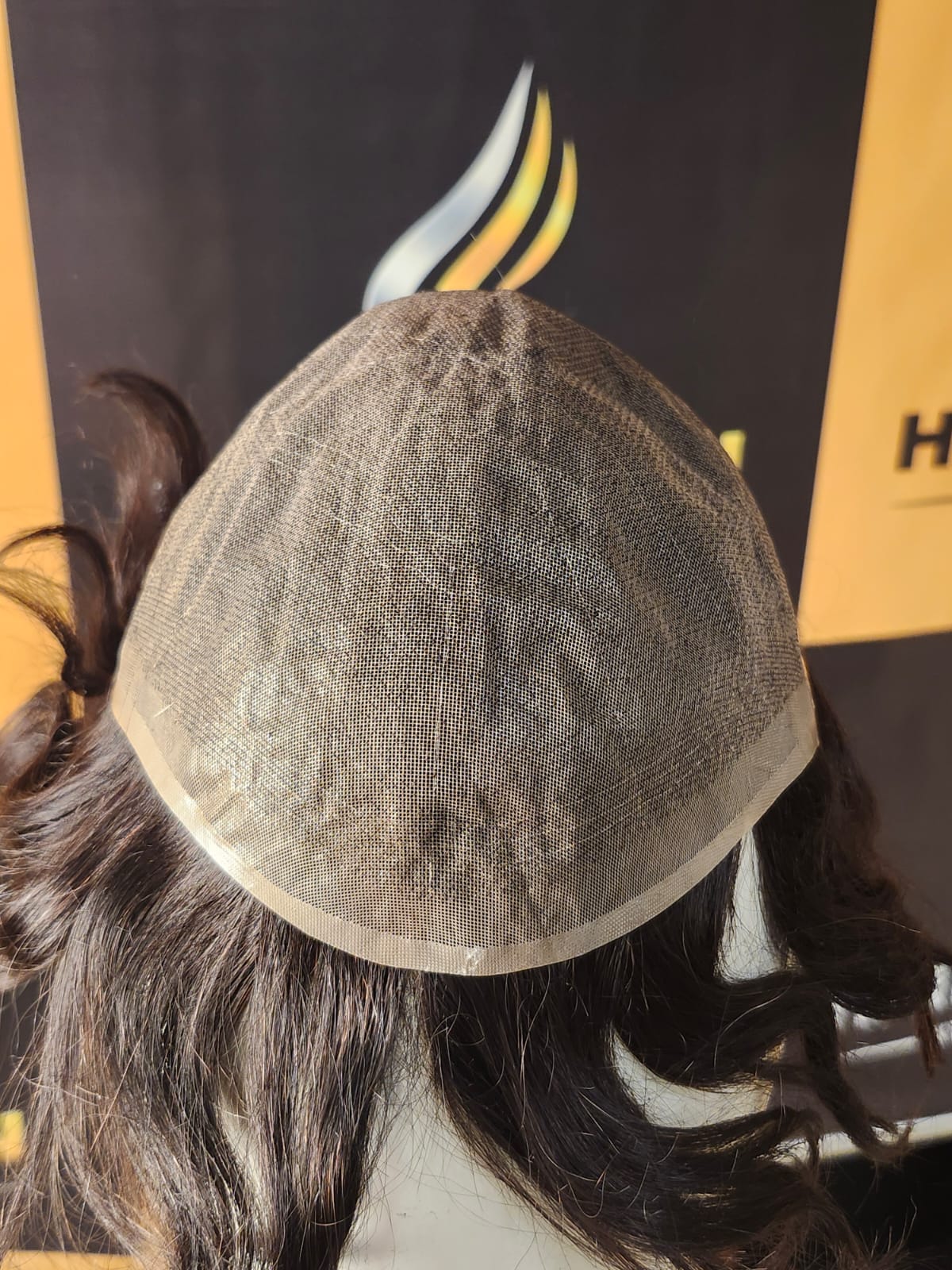Close-up of a hairpiece on a mannequin head with a blurred background